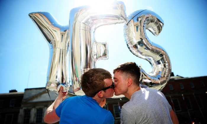 Paul Bonass and Luke Hoare Greene kiss in front of yes balloons at Dublin castle Photograph: Brian Lawless/PA