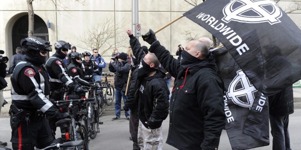A police line holds back white supremacist during a white power rally in downtown Calgary on Saturday, March 19, 2011. Police kept them apart from another group holding an anti-racist demonstration nearby. THE CANADIAN PRESS/Larry MacDougal