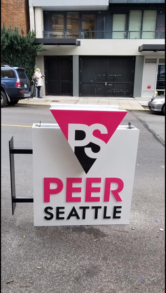 The non-profit formerly known as SASG (Seattle Area Support Group) is now PEER SEATTLE and install a new sign at their new location to reflect that. Photo by Marc Shelffo via Tony Radovich/Facebook