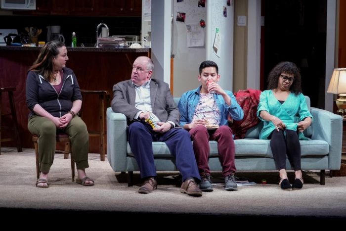 The cast of Cheryl Strayed's TINY BEAUTIFUL THINGS onstage at Seattle Rep through June 29, 2019: Julie Briskman, Charles Leggett, Justin Huertas and Chantal DeGroat examining what might be the ugliest top in history while sitting on the stupidest family room couch choice in history. 